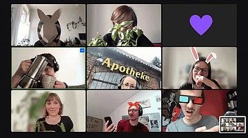 Acht Personen in einer Videokonferenz, die unterschiedliche Dinge tun. Beispielsweise halten Personen eine Kaffeemaschine oder Pflanzen in die Kamera, eine Person ist draußen und wieder eine andere hat eine 3-D-Brille auf.