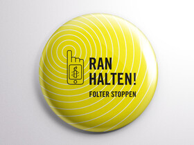 Ein gelber Button auf dem „ranhalten! Folter stoppen“ geschrieben steht.