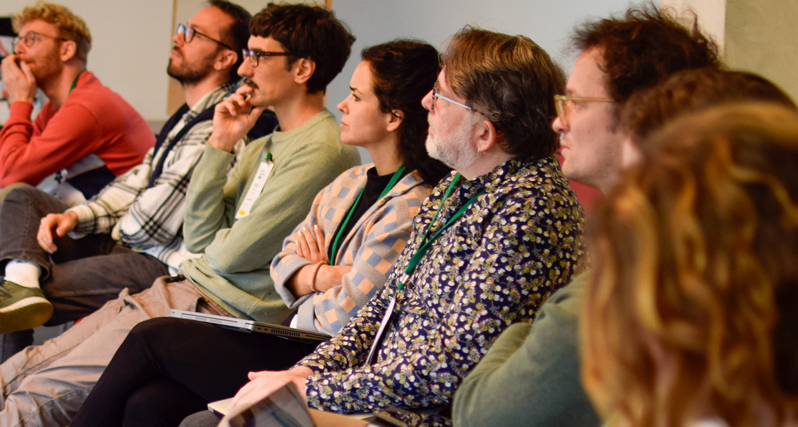 Mesnchen auf Stühlen in einer Reihe, aufmerksam zuhörend.